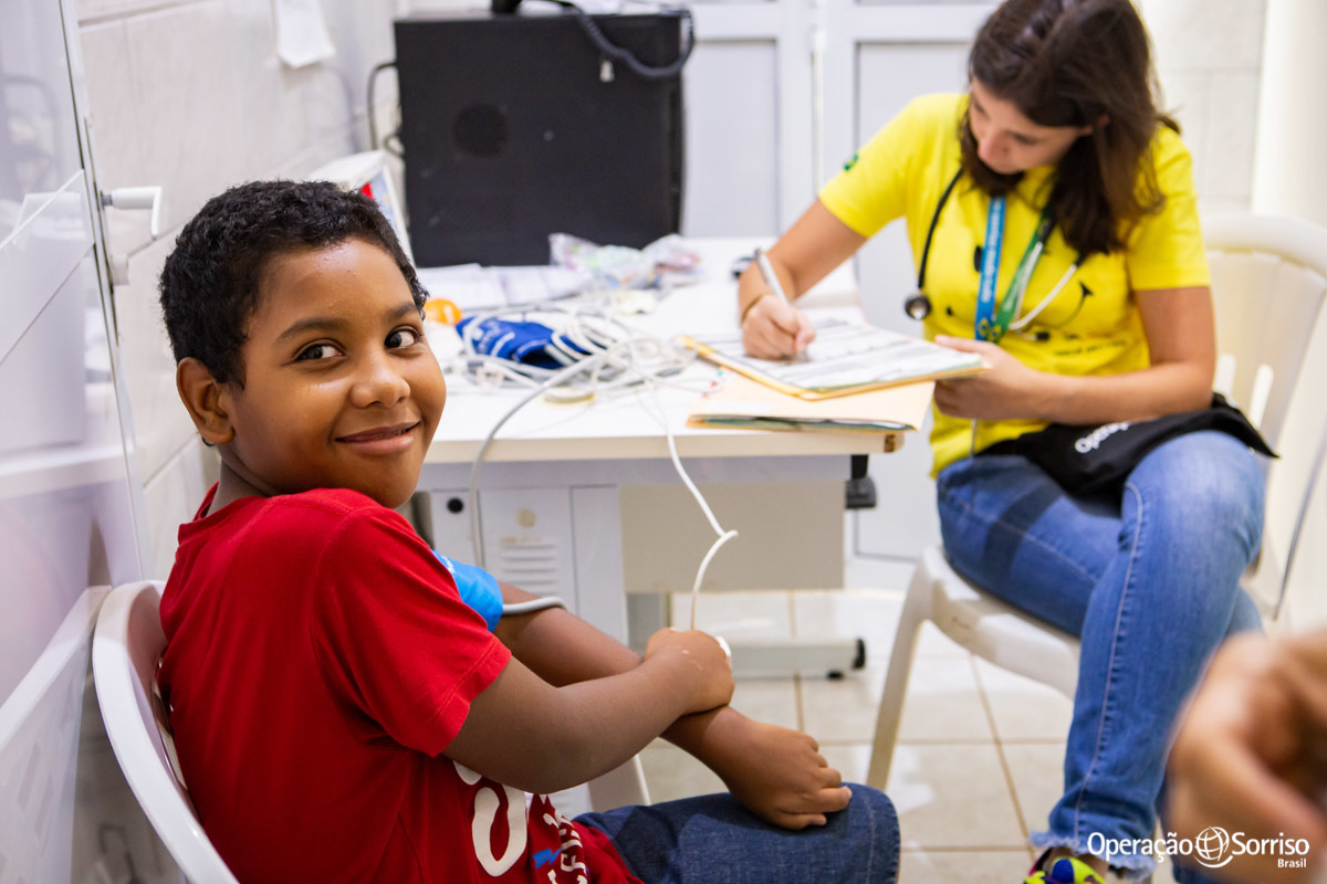 criança sendo atendida pela pediatra e sorrindo