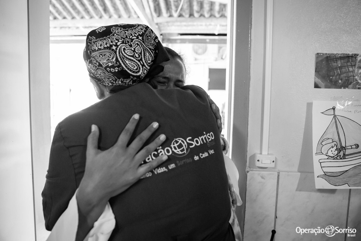 mãe chorando e abraçando a psicologa