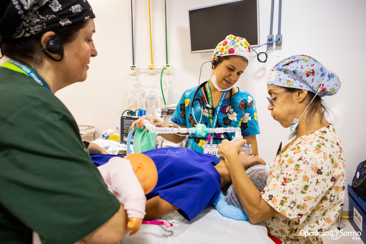 anestesista brincando com criança enquanto coloca mascara em seu rosto