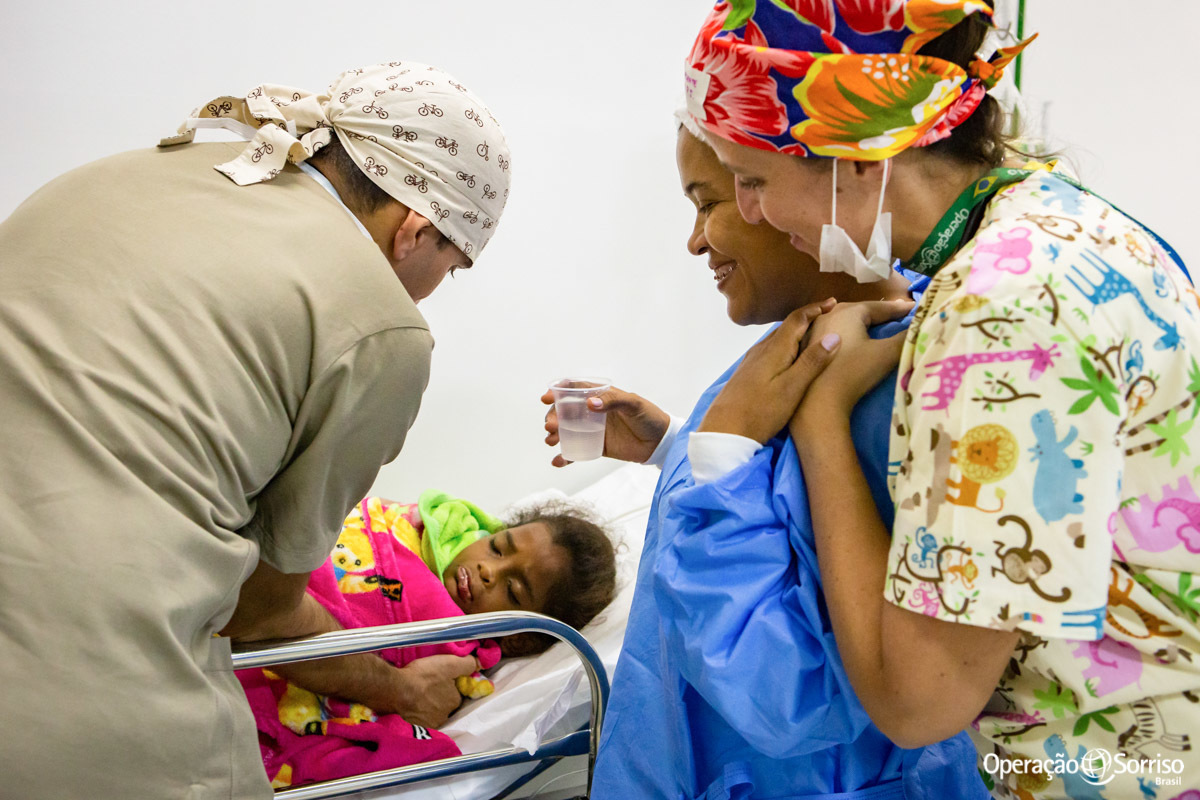 mãe olhando para filha após e médica a abraçando a cirurgia