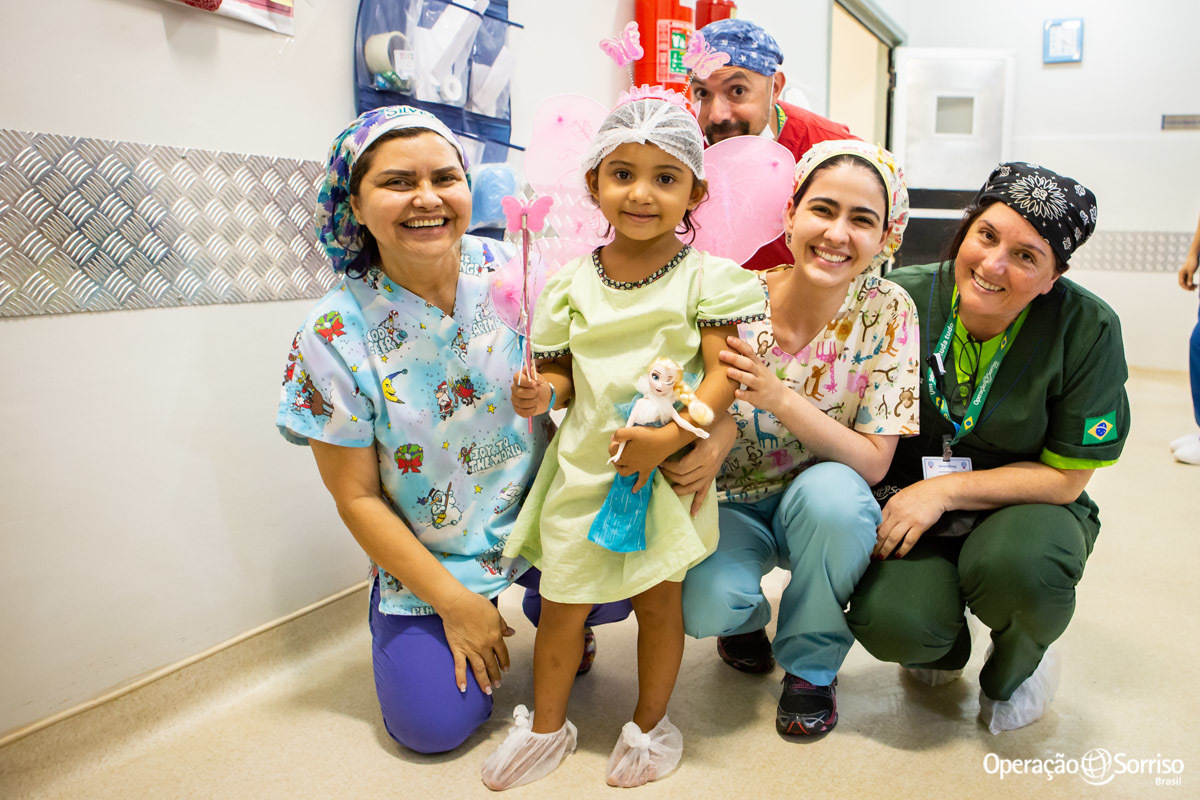 voluntários com criança fantasiada de fada
