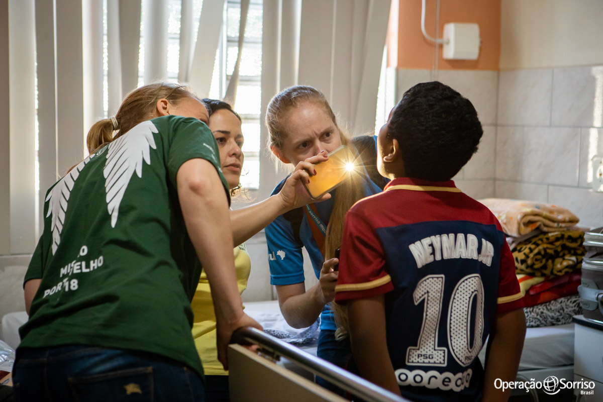 fonoaudiólogas e cirurgia olhando boca de criança cirurgiada