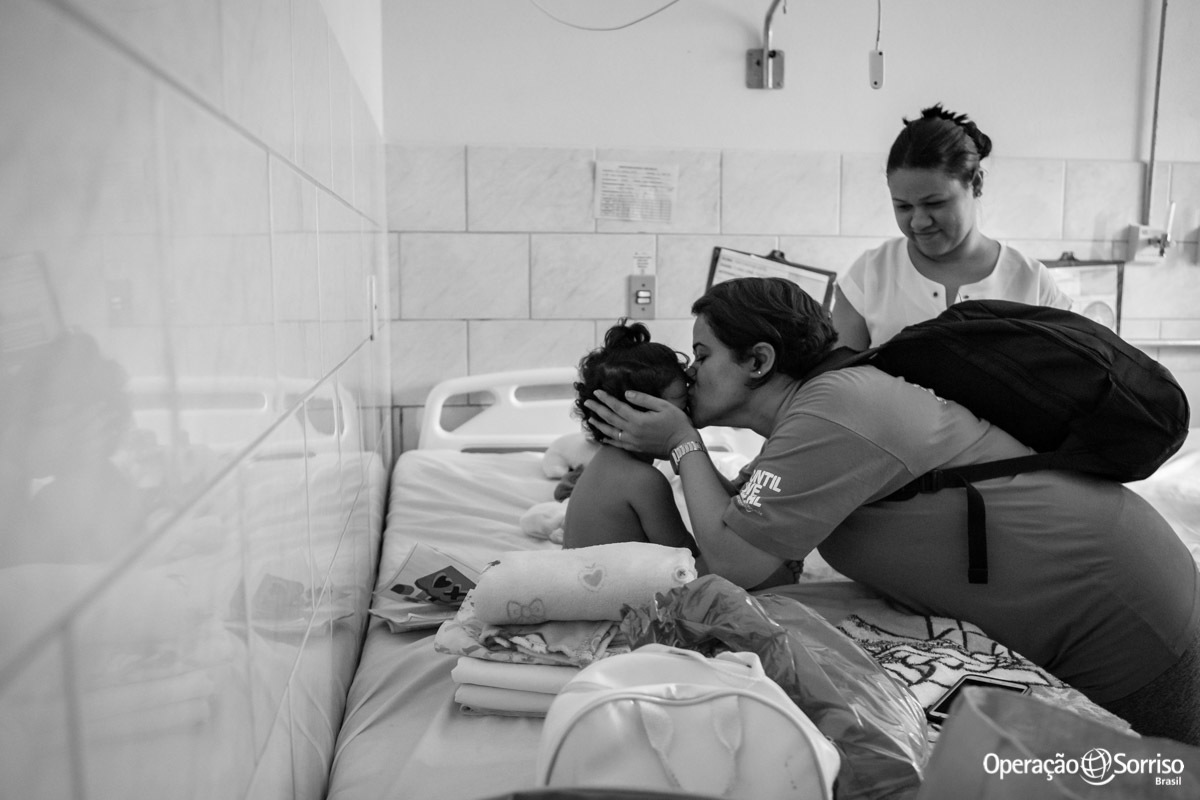 enfermeira beijando testa de criança 