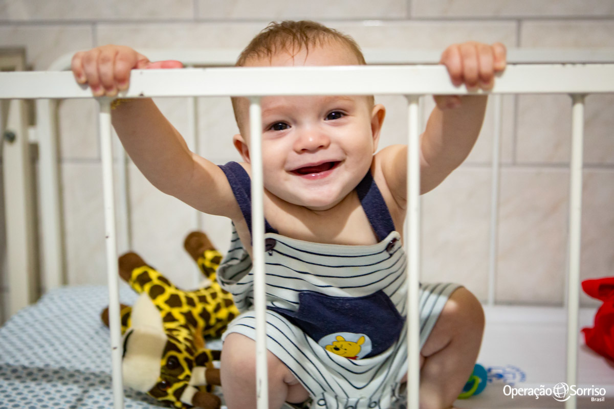 menino brincando em berço e sorrindo
