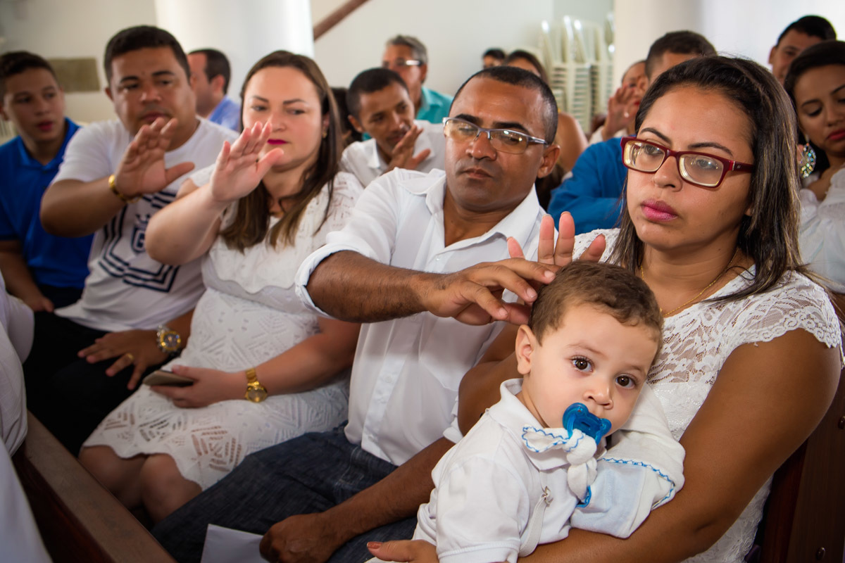 padrinhos e pais abençoam criança