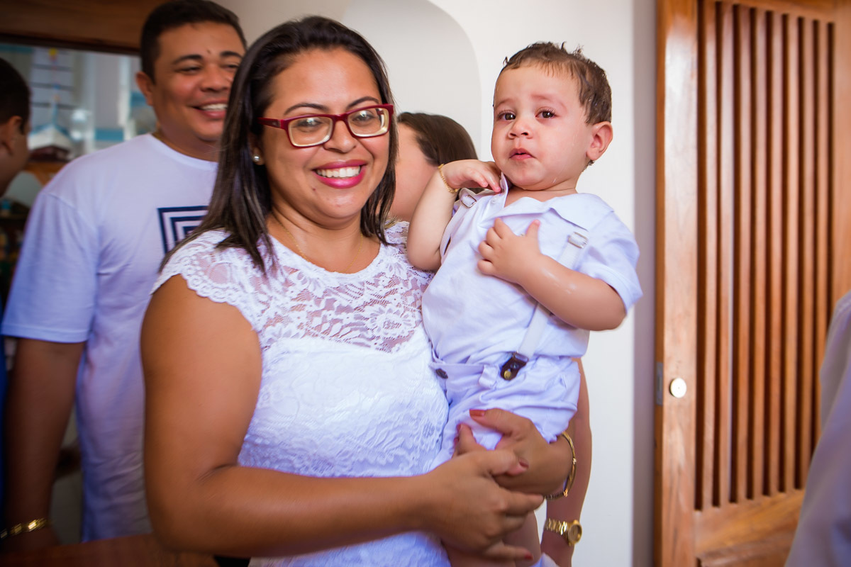 madrinha segurando criança e sorrindo após ser batizada