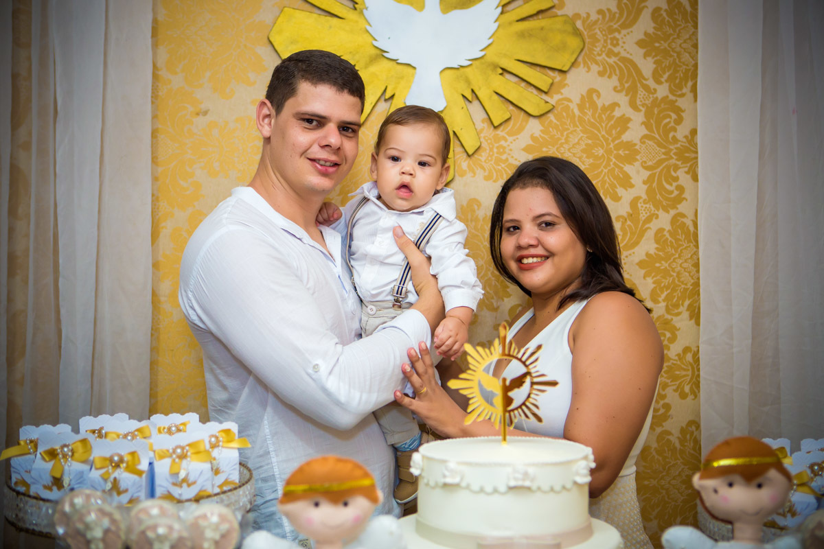 pais com a criança no colo na mesa de doces