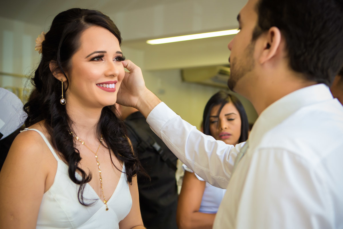 noiva olhando para o noivo enquanto ele ajeita seu cabelo durante cerimonia em cartório de Parnamirim