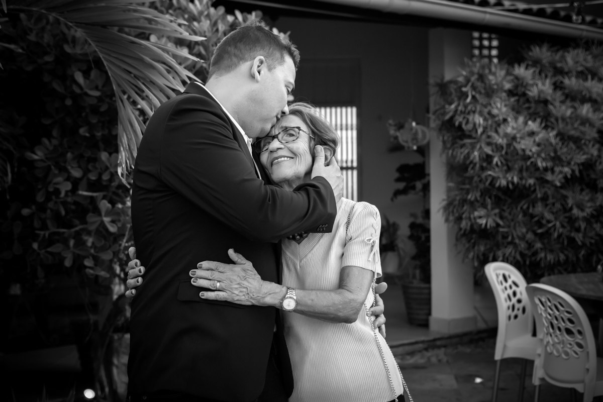 mãe do noivo recebendo um beijo do filho em sua testa em casamento civil em natal Rn