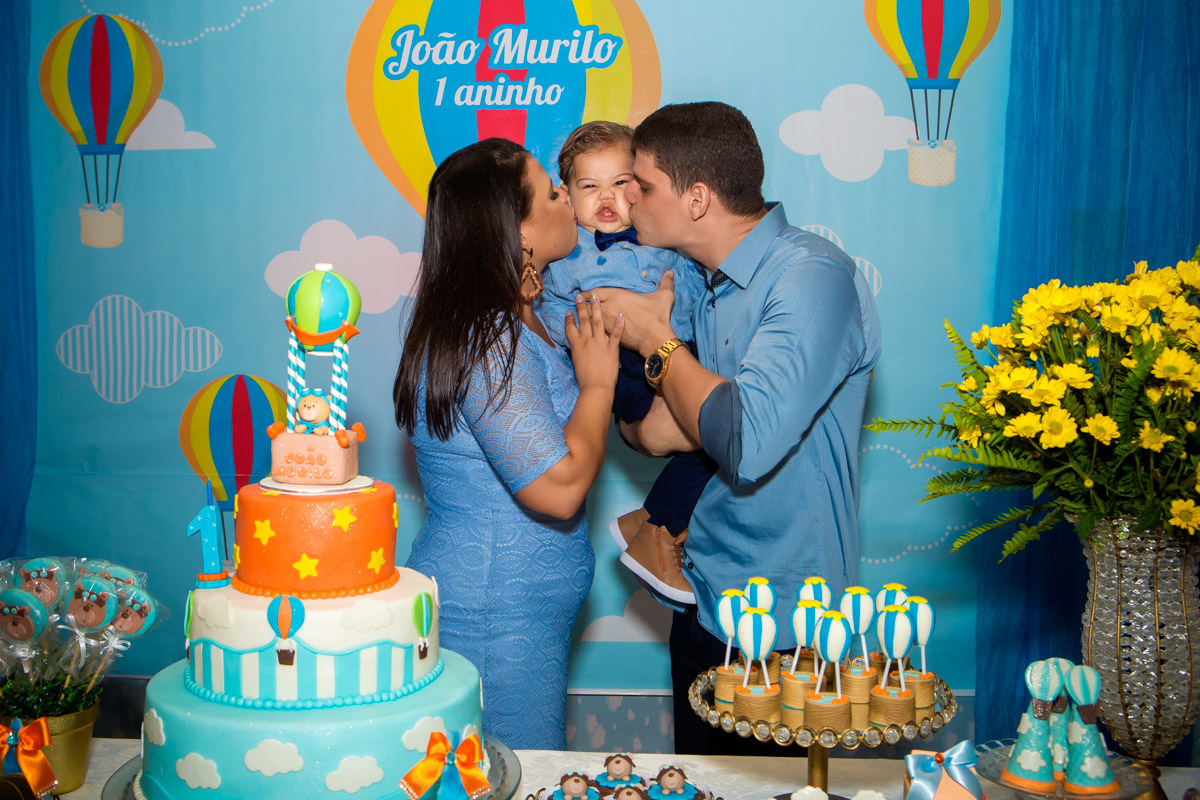 pais beijando filho que faz careta no aniversário ursinho baloeiro