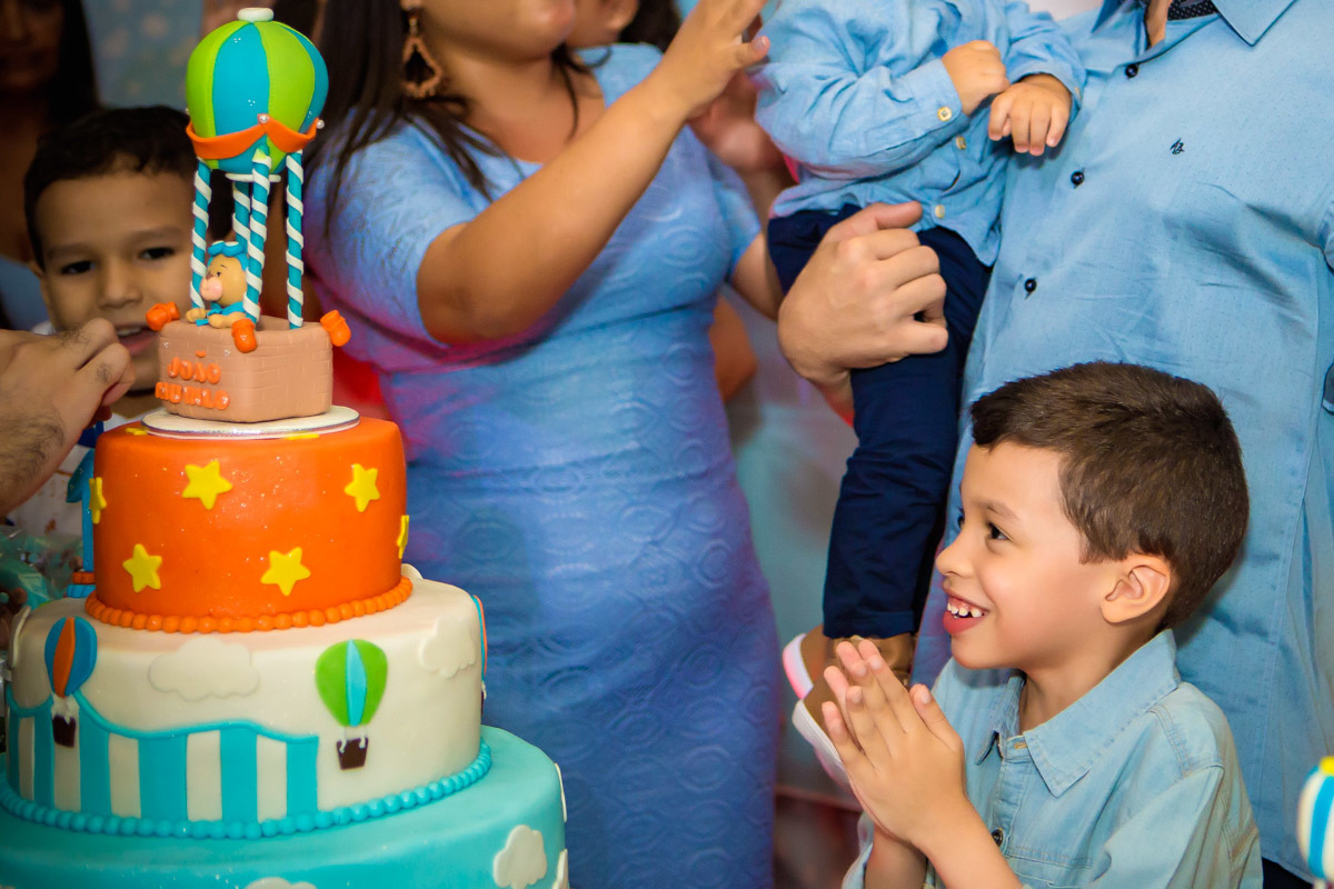 primo do aniversariante olhando para o bolo na hora dos parabens no aniversario ursinho baloeiro