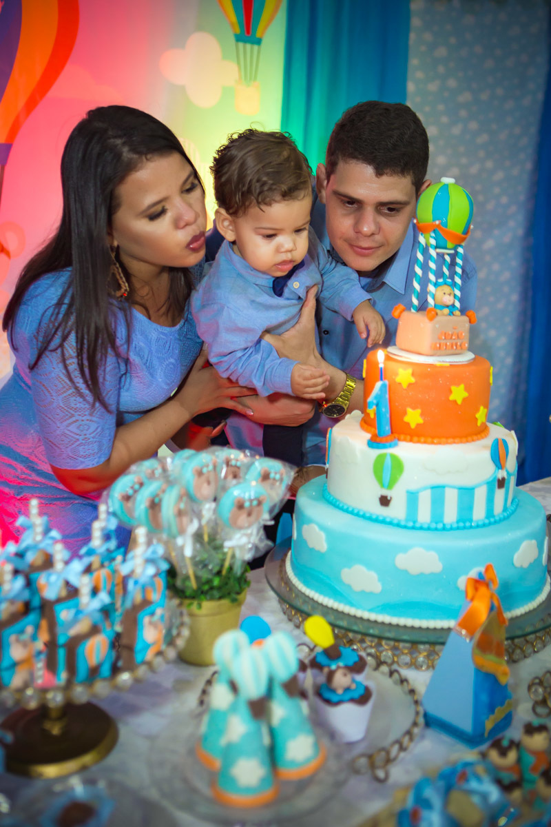 bebe colo do pai apagando a vela com a mãe no aniversário ursinho baloeiro