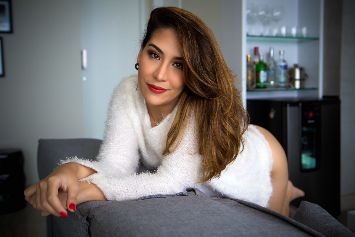 mulher no sofá com blusa de pelo branca 