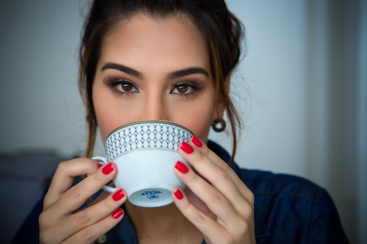 retrato de mulher segurando xicara de café proximo ao rosto