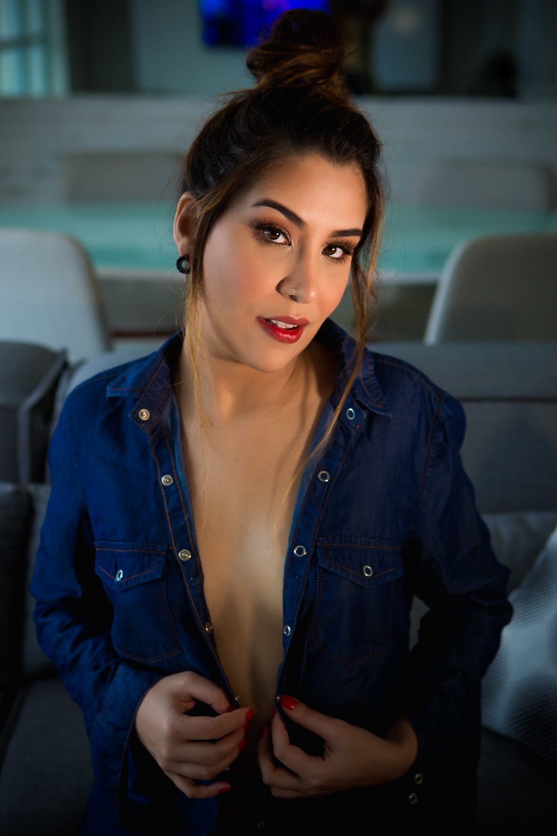 mulher sentada no sofá com camisa de botão jeans aberta