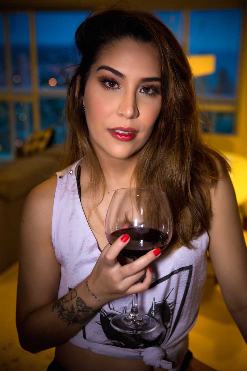 mulher sentada em balcão com taça de vinho na mão