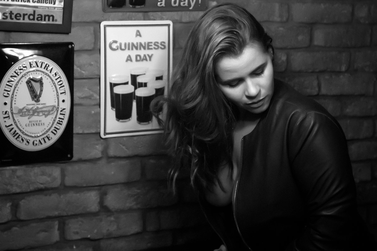 mulher com jaqueta aberta sem sutiã olhando para baixo