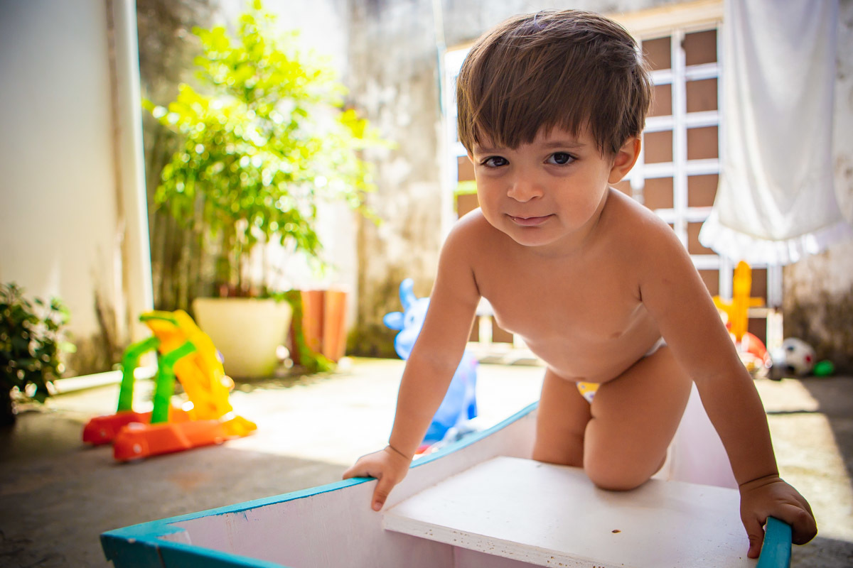 criança brincando em barco e olhando para camera