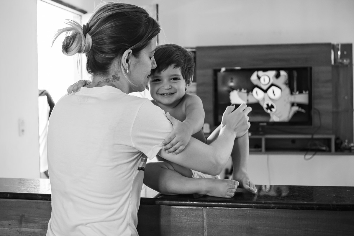 criança sentado em balcão abraçando a mãe