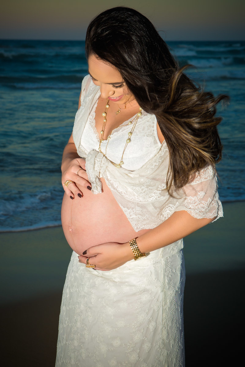 Gestante segurando barriga na praia