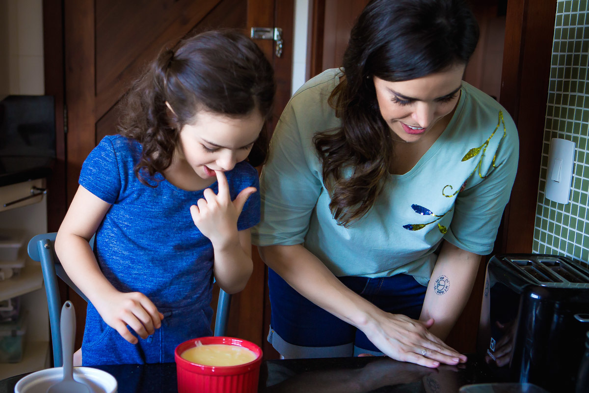 filha lambendo dedo que colocou no leite condensado