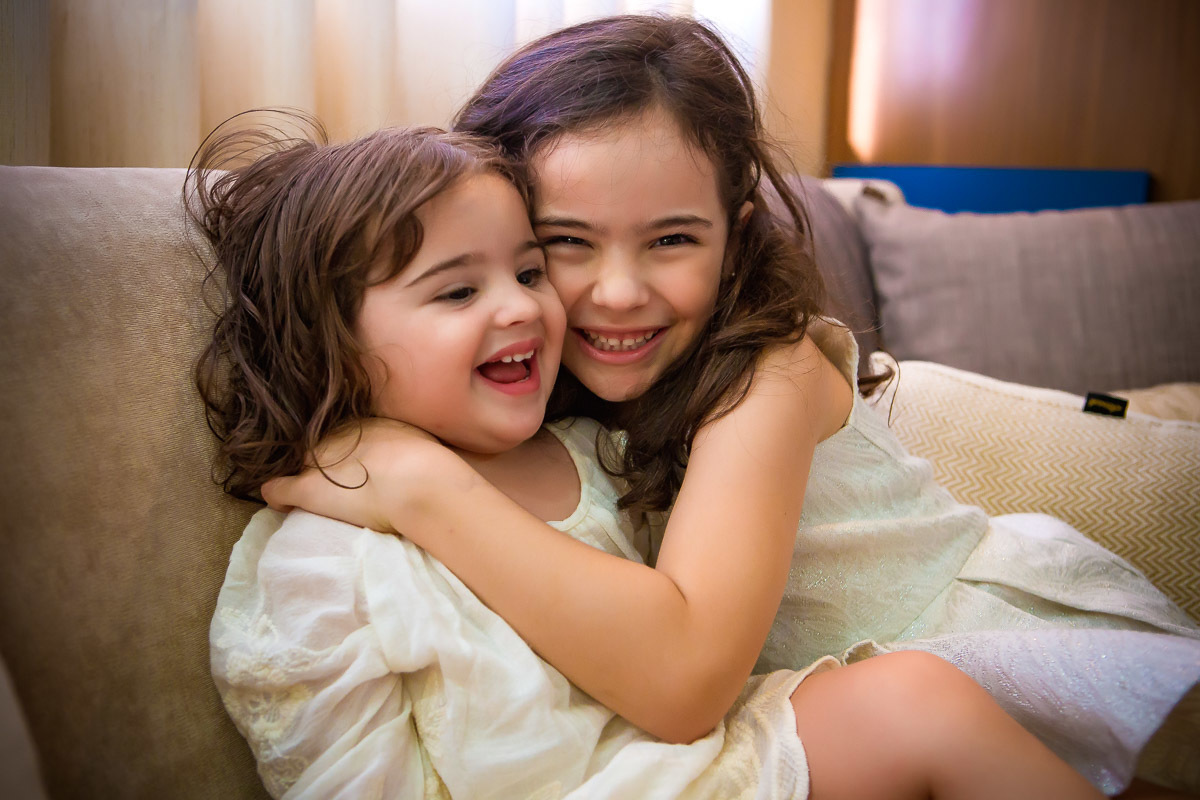 irmãs abraçadas sentadas no sofá