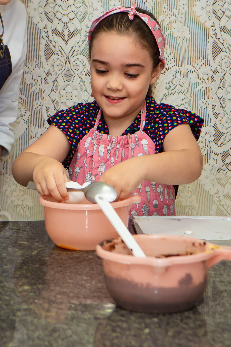Menina quebrando ovo e sorrindo 