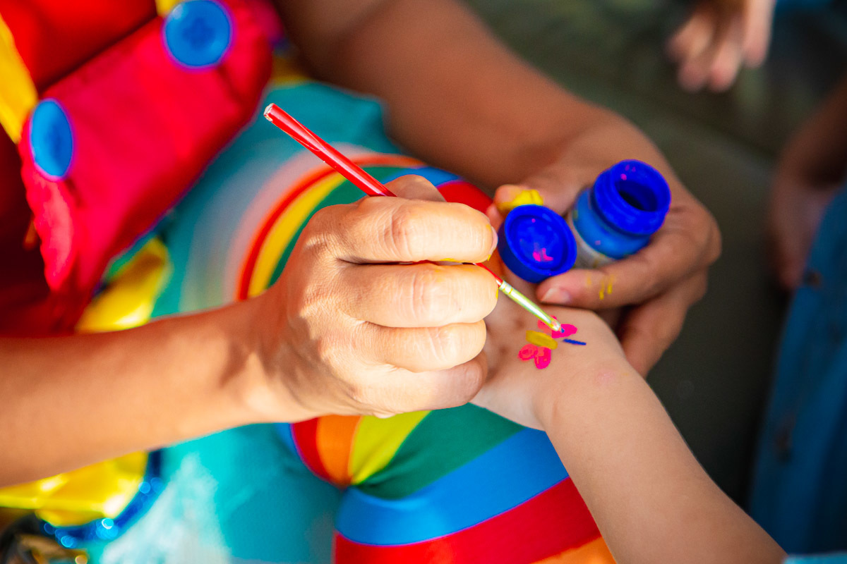Animadora desenhando borboleta na mão de criança