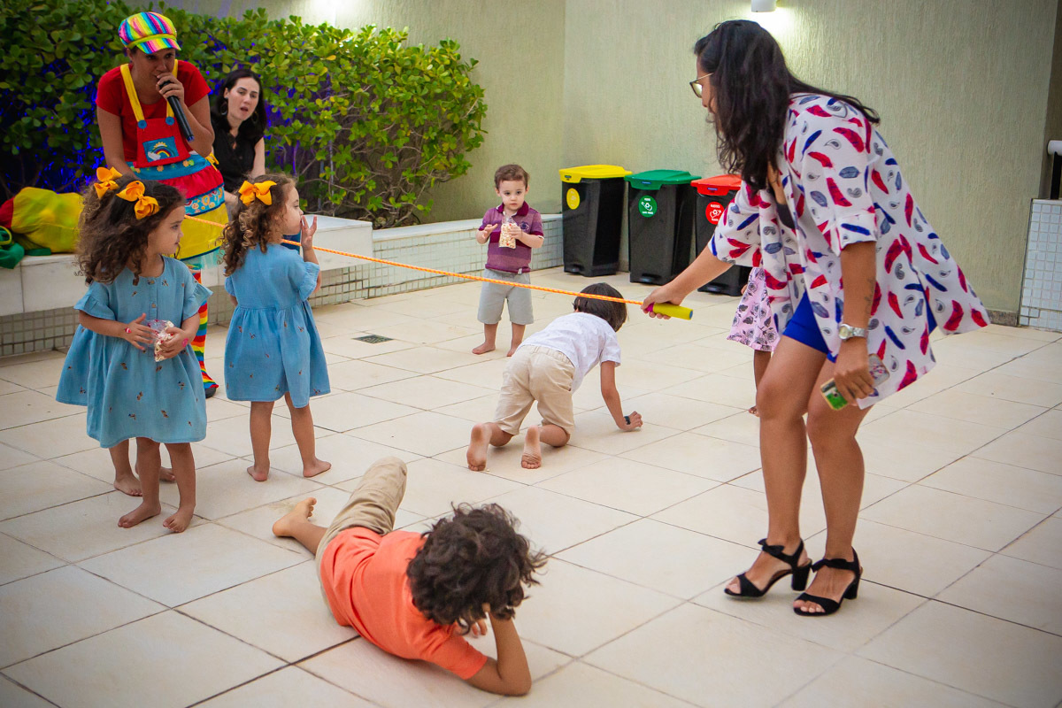 crianças passando por debaixo da cordinha e brincando