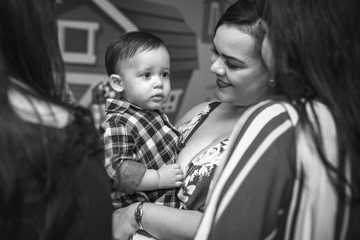 Mãe com aniversariante no colo que olha para amiga da mãe e encara