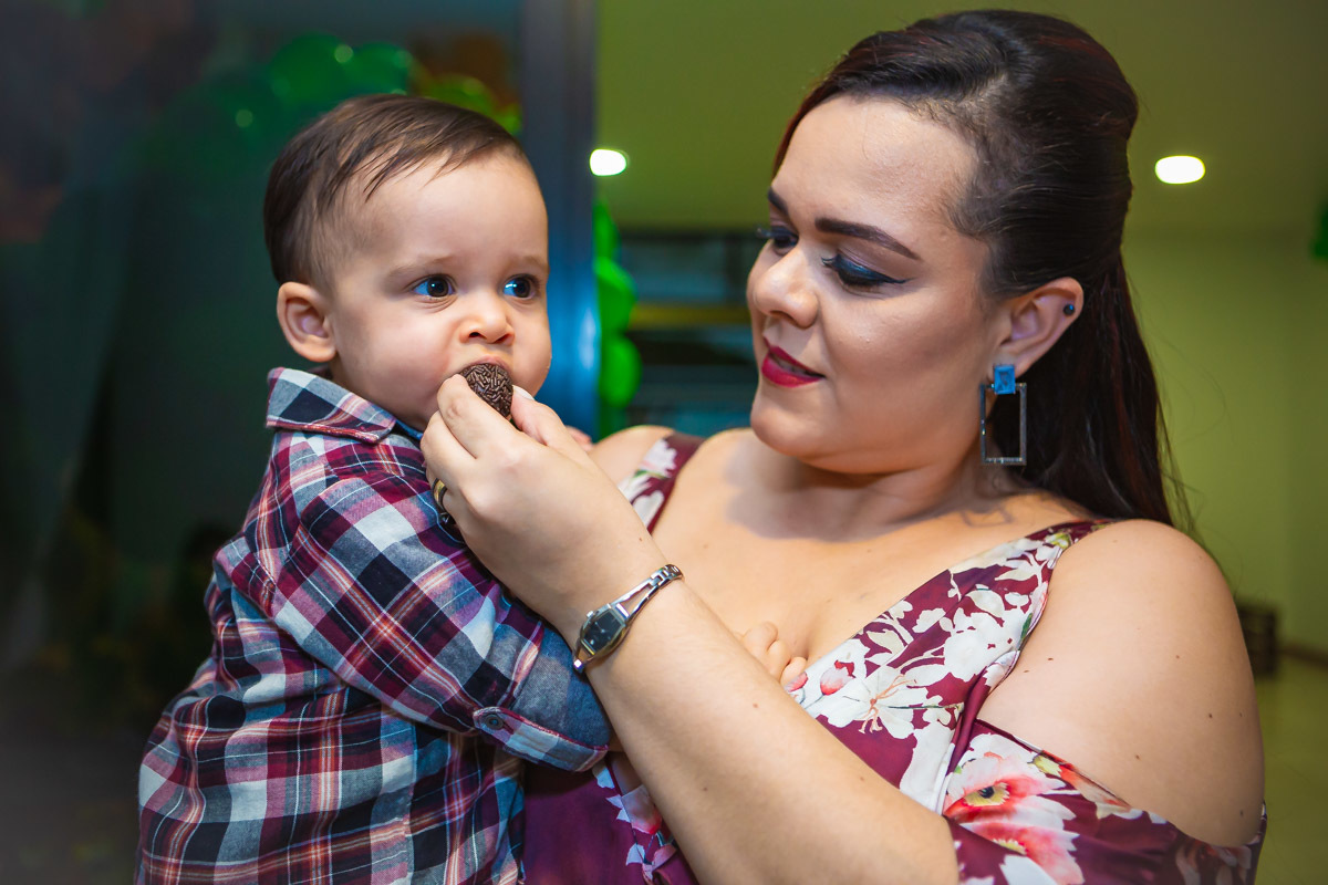 mãe dando brigadeiro pela primeira vez para aniversariante em festa com tema a fazendinha