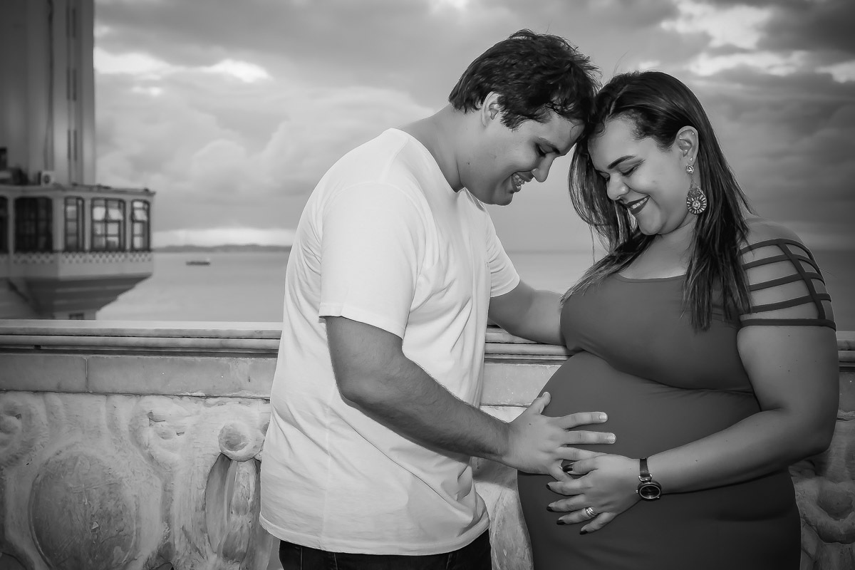 Pais com mão na barriga e se abraçando proximo ao elevador Lacerda no Pelourinho em Salvador.