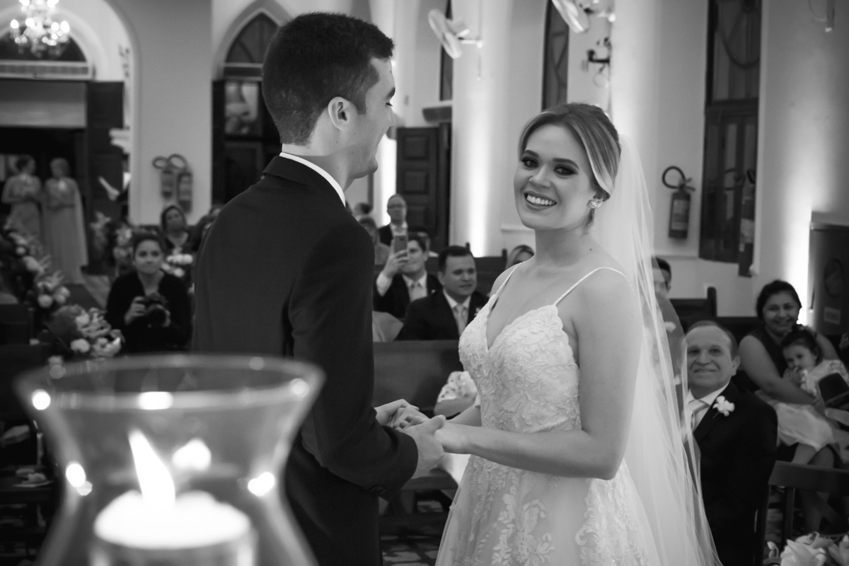Celebração do casamento na Igreja Santa Terezinha, noiva sorrindo enquanto noivo a olha.