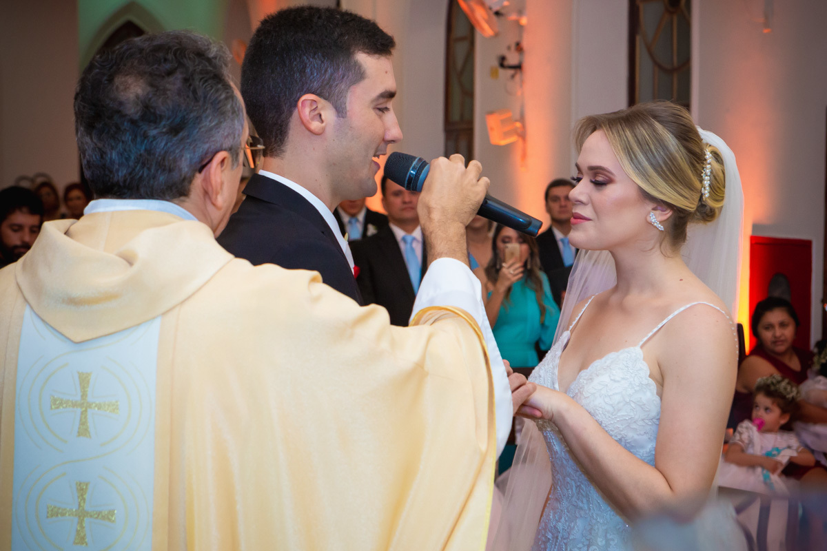 Celebração do casamento na Igreja Santa Terezinha, noivos se olhando enquanto fazem os rituais do casamento.
