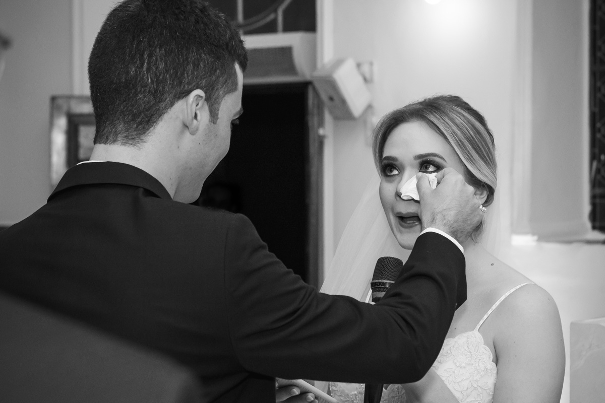 Celebração do casamento na Igreja Santa Terezinha, noivos enxugando o rosto da noiva que chora.