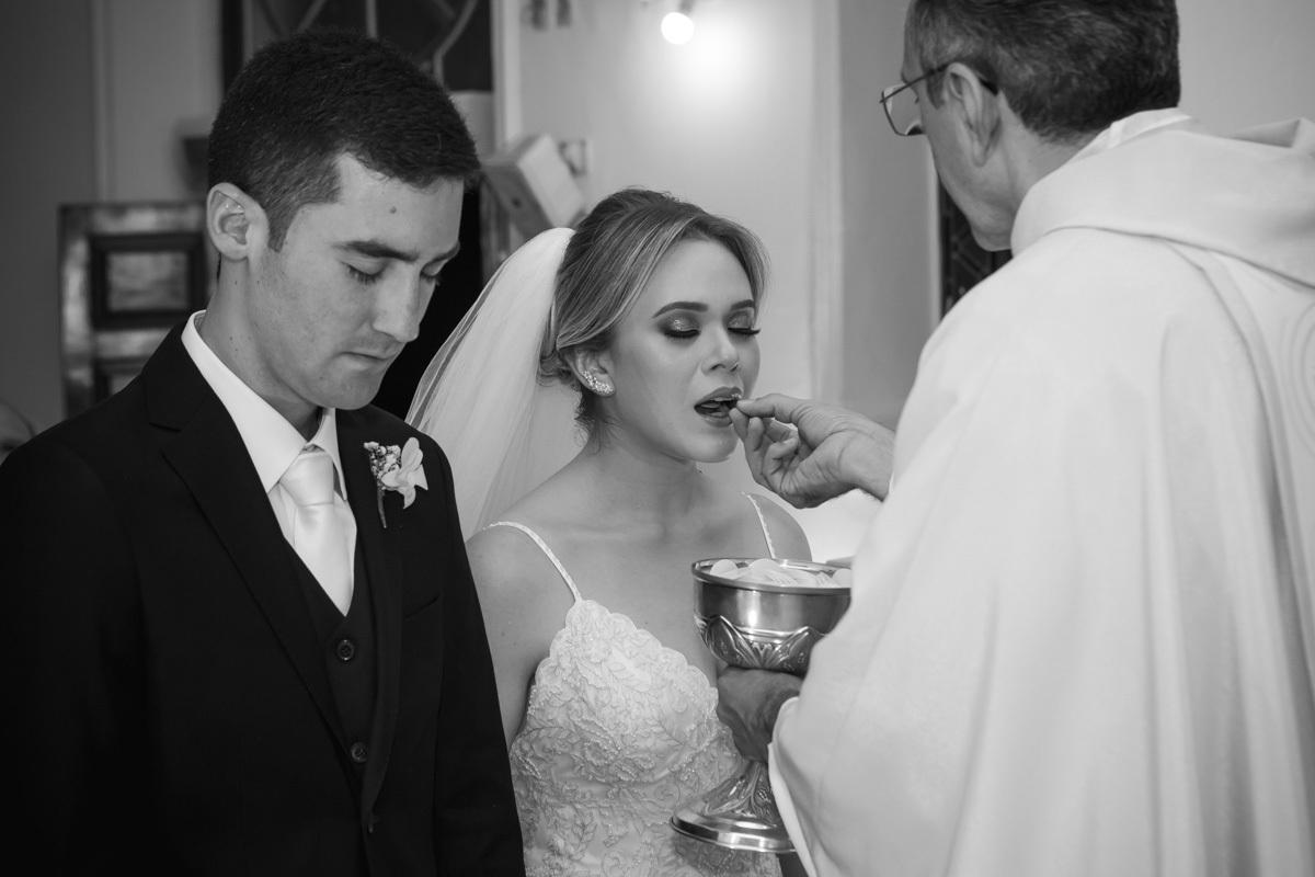 Celebração do casamento na Igreja Santa Terezinha, noiva comungando.