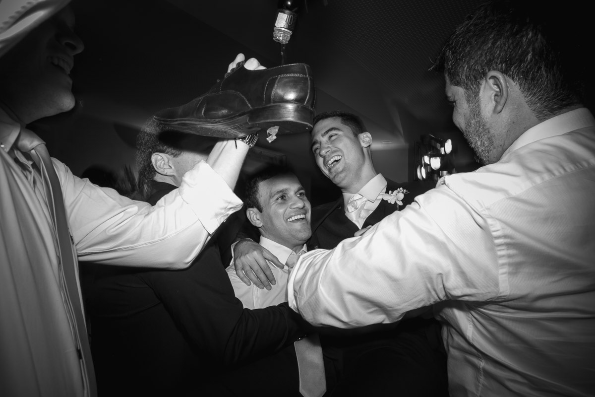 amigos colocando bebida no sapato do noivo