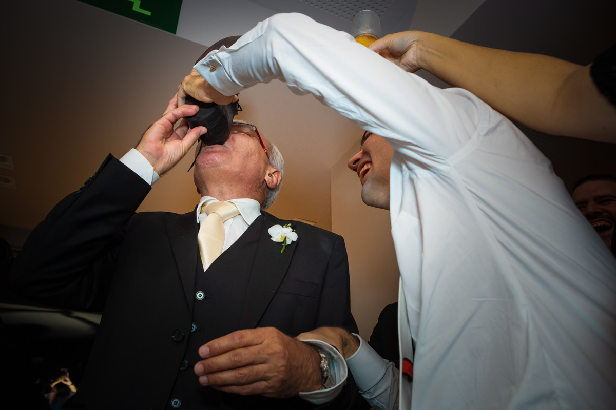 pai do noivo bebendo diretamente do sapato