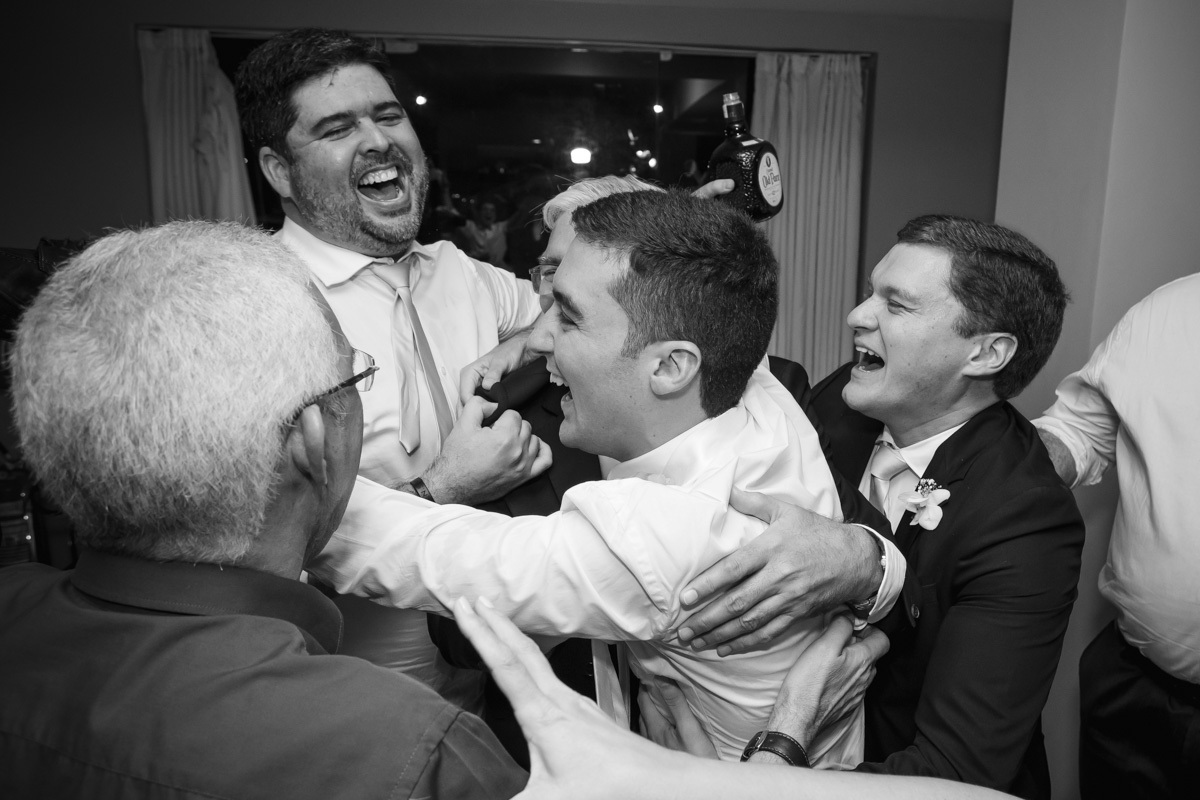 noivo, irmão, pai e amigos se abraçando e rindo após beber 