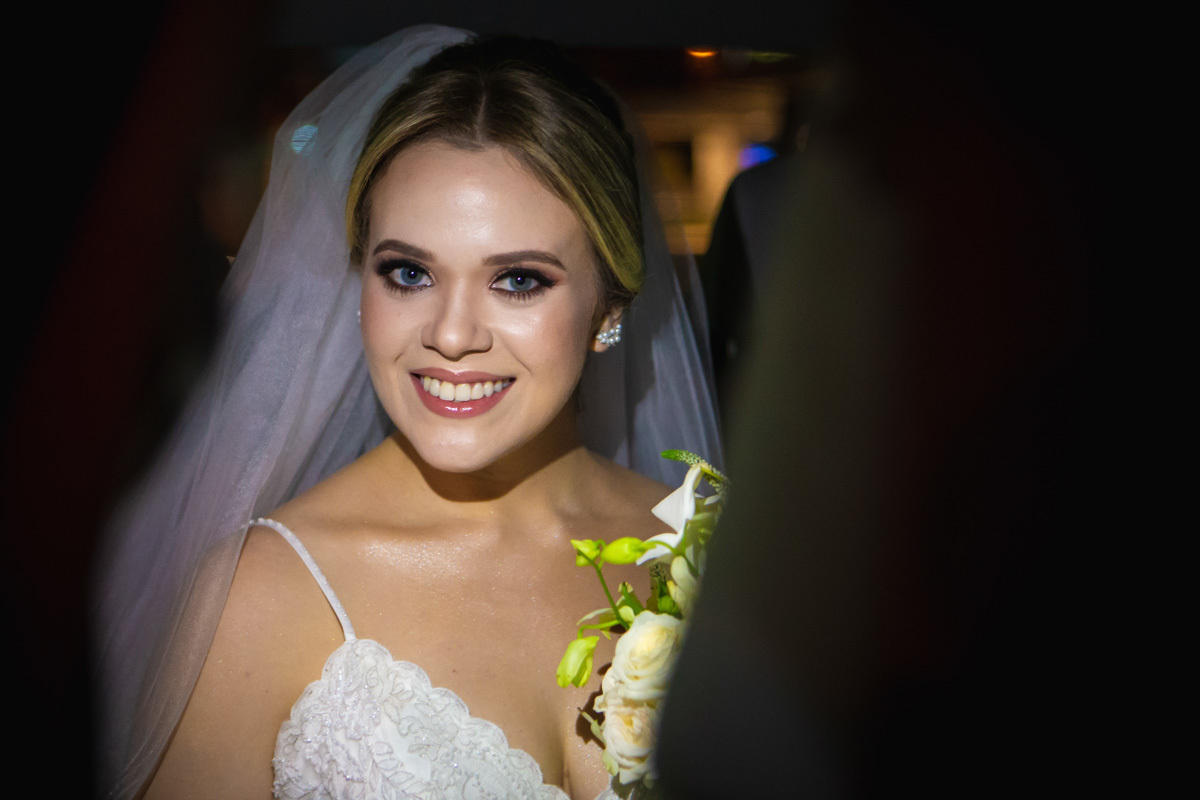 noiva olhando para a foto e segurando o buque