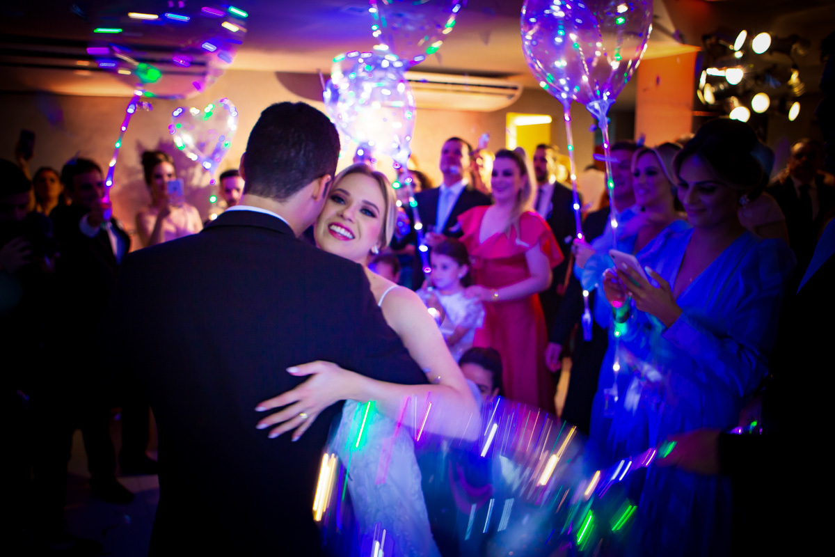 noivos dançando de rosto colado e noiva sorrindo