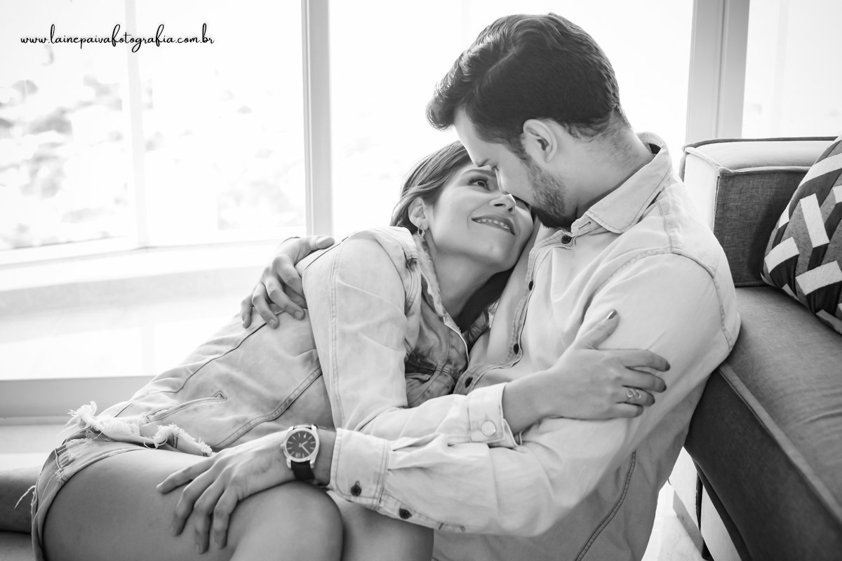 Casal sentados no chão se abraçando.