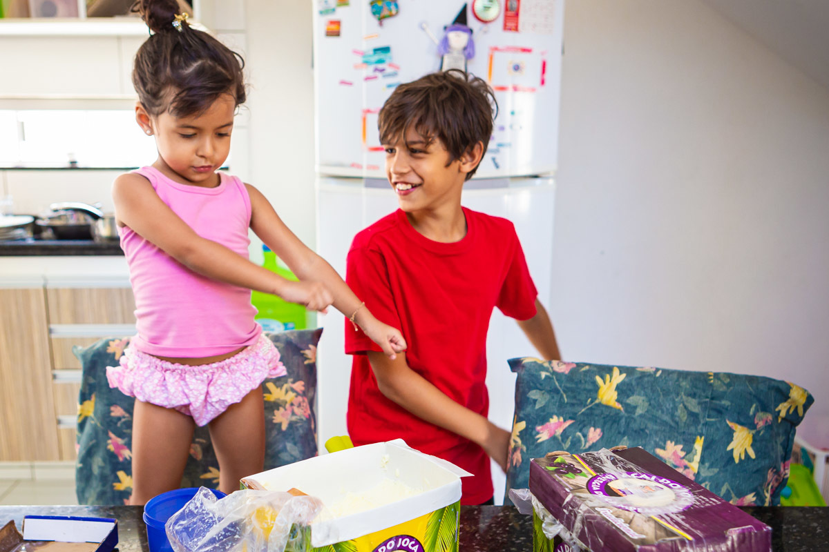 menino com irmã dançando em cima da cadeira