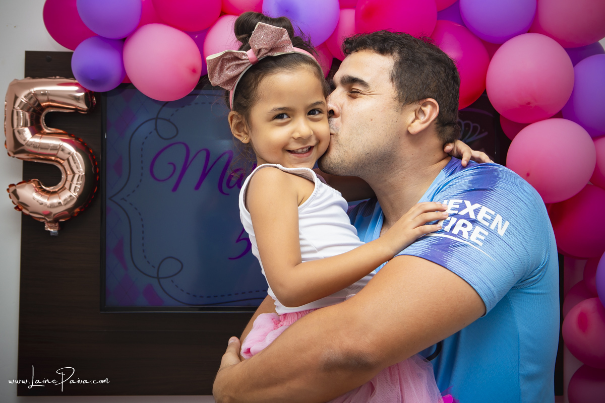 menina no colo do pai abraçada e ganhando beijo