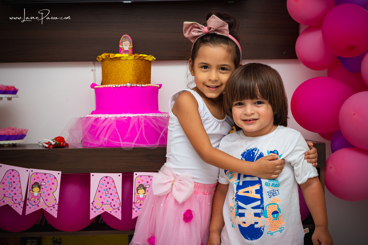 menina abraçada com primo em aniversário