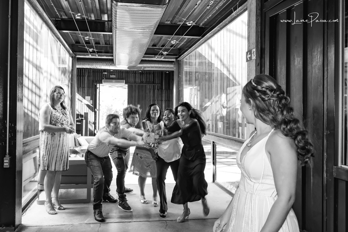 noiva olhando para amigos tentando pegar o buque dentro restaurante Nau, após casamento no 5 oficio de notas em Natal RN