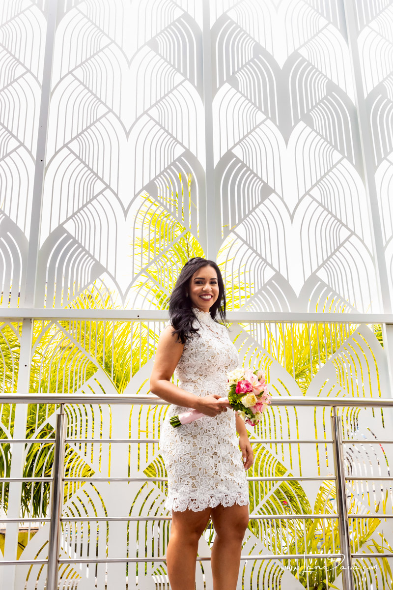 noiva em pé segurando buque e sorrindo na recepção do casamento civil no Thome Galeria BIstro após casamento no cartório CIdade Jardim em Natal/RN