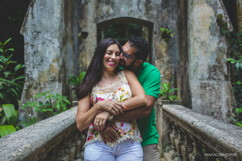 Casal se abraça apaixonadamente em uma ponte antiga de pedra. Fotografia de casal feita por Ana Kacurin no Rio de Janeiro - RJ.