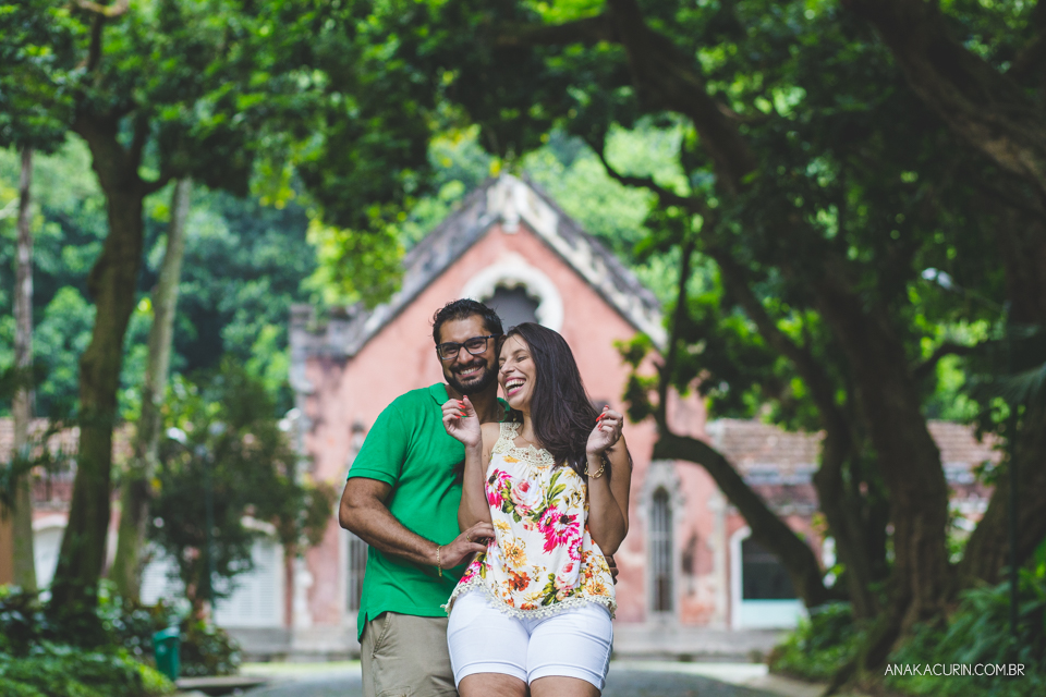 Casal se abraça, em frente a uma bela  e majestosa construção antiga. Fotografia de casal feita por Ana Kacurin no Rio de Janeiro - RJ.