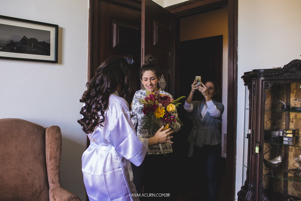 Noiva Larissa recebe seu bouquet de flores coloridas com um lindo sorriso de felicidade
